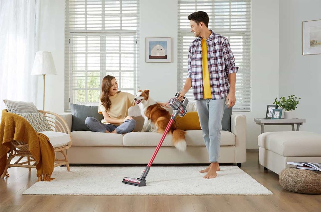 Person using a cordless vacuum to clean a Florida-style home living room floor